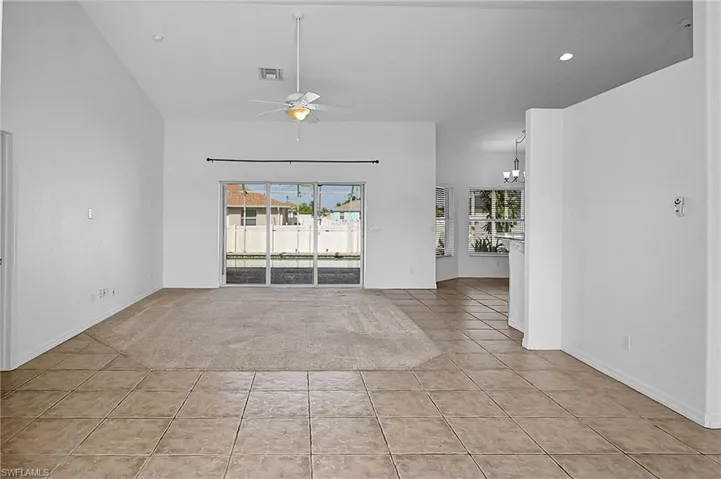 Unfurnished room with light tile patterned floors, healthy amount of natural light, a ceiling fan, a chandelier, and recessed lighting