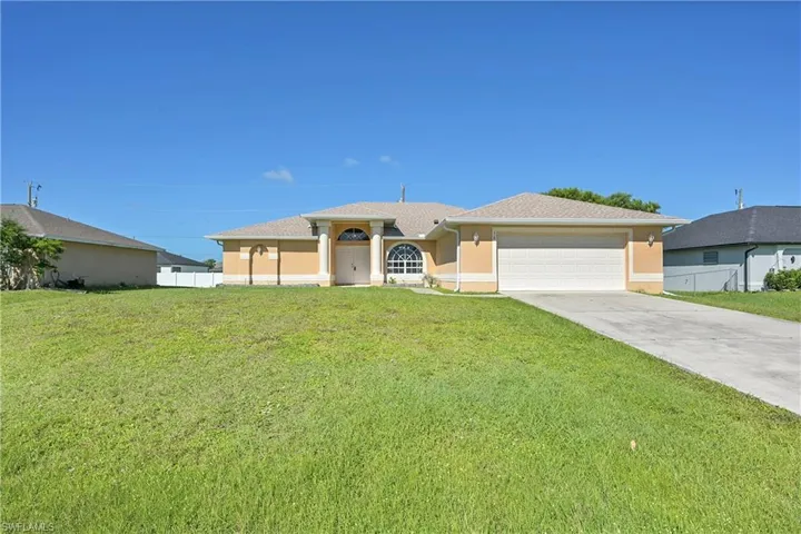 Ranch-style home featuring concrete driveway, stucco siding, and a garage
