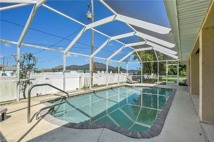 View of pool featuring a sunroom, a patio area, glass enclosure, and a fenced backyard