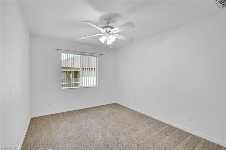 Spare room with light carpet and a ceiling fan