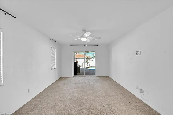 Spare room with a ceiling fan and light carpet