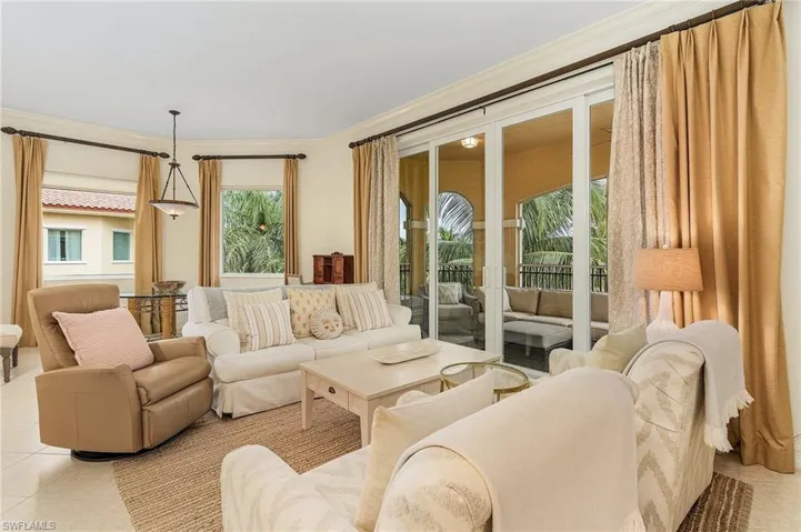 Living room with ornamental molding and light tile flooring