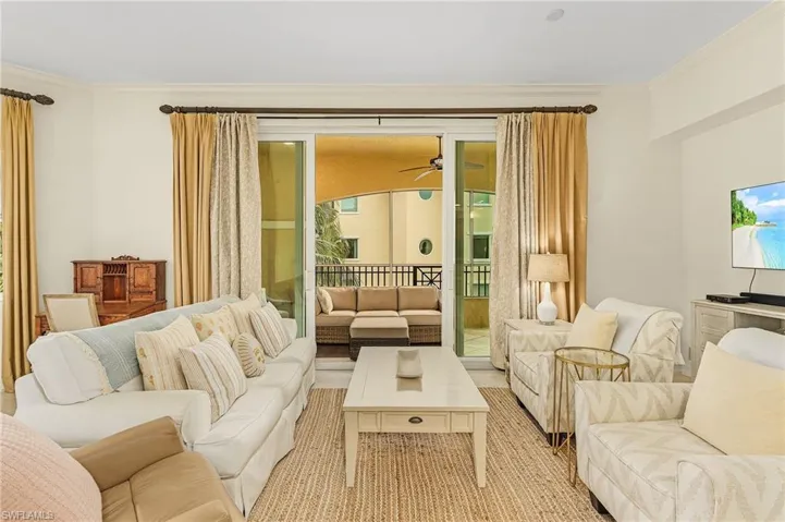 Living room featuring ceiling fan and crown molding