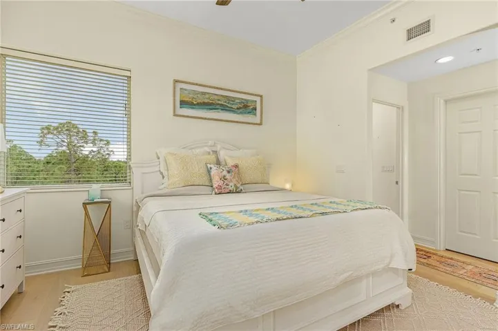 Bedroom featuring ceiling fan, light hardwood / wood-style floors, and crown molding