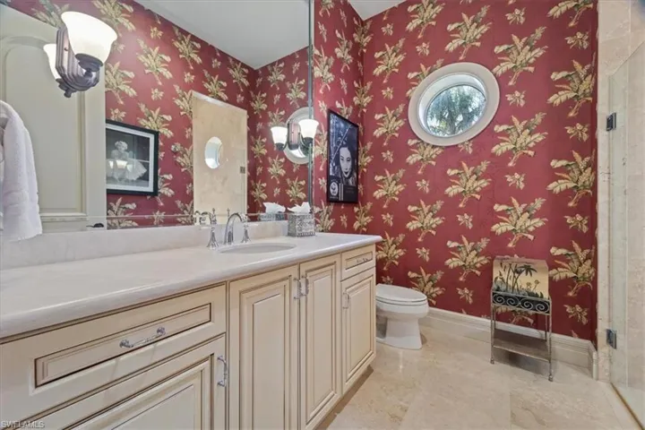 Bathroom with baseboards, vanity, marble finish floor, and toilet