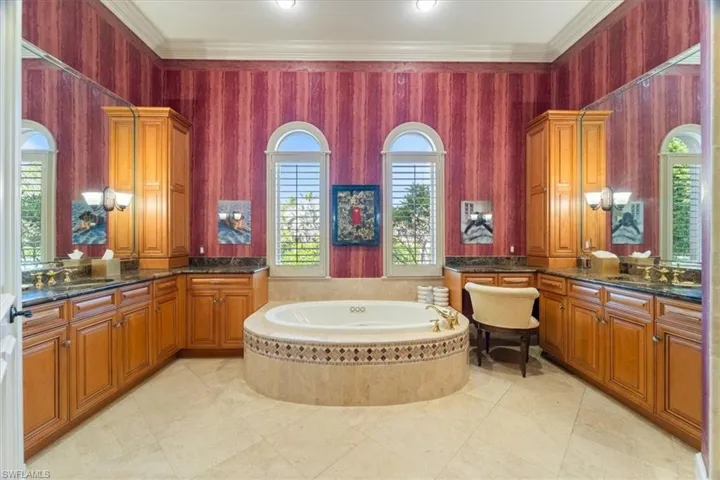 Full bathroom with a bath, vanity, and crown molding