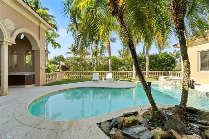 View of swimming pool featuring fence, a patio, a fenced in pool, and an in ground hot tub