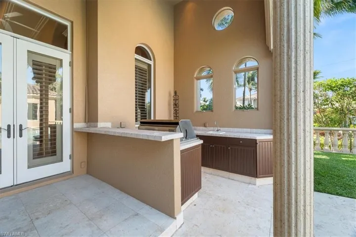 View of patio with an outdoor kitchen, french doors, and a sink