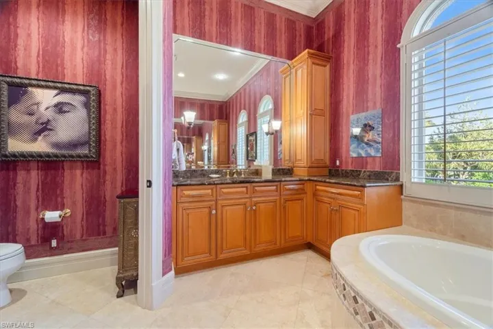 Full bath featuring a bath, toilet, crown molding, and vanity