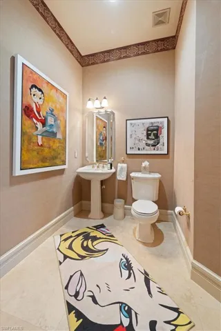 Half bath with visible vents, tile patterned flooring, baseboards, and toilet
