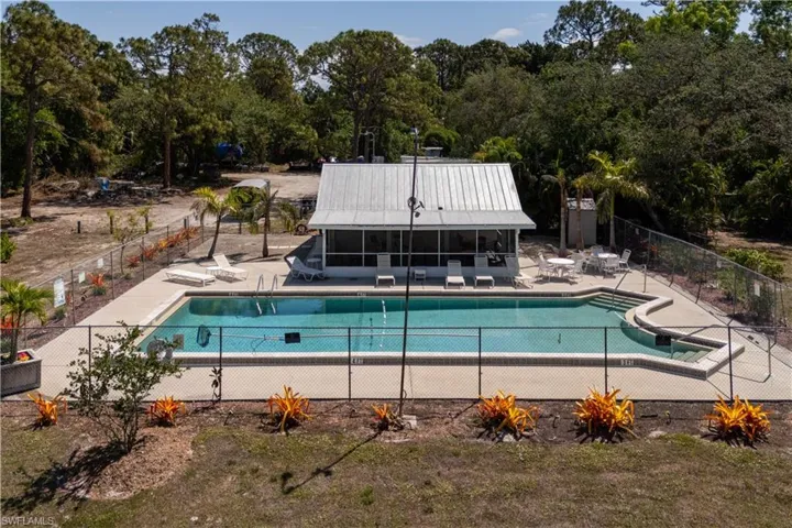 Community pool featuring a sunroom, a patio area, and fence