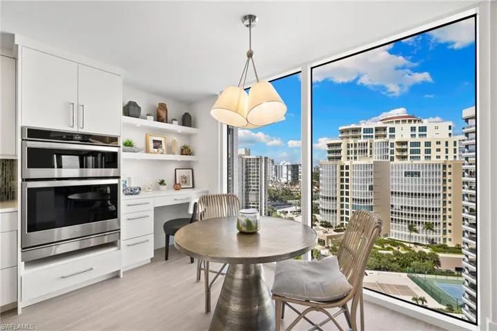 Dining room featuring light wood finished floors, a wall of windows, a city view, and built in desk