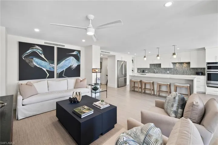 Living area with a ceiling fan, recessed lighting, and light wood-style flooring
