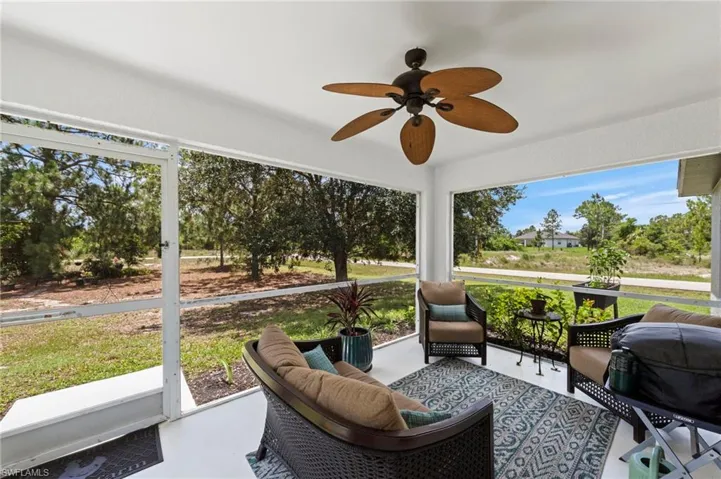 Rear screened lanai with fresh paint and upgraded outdoor fan overlooking a generous yard with over 1/2 acre of space to enjoy!