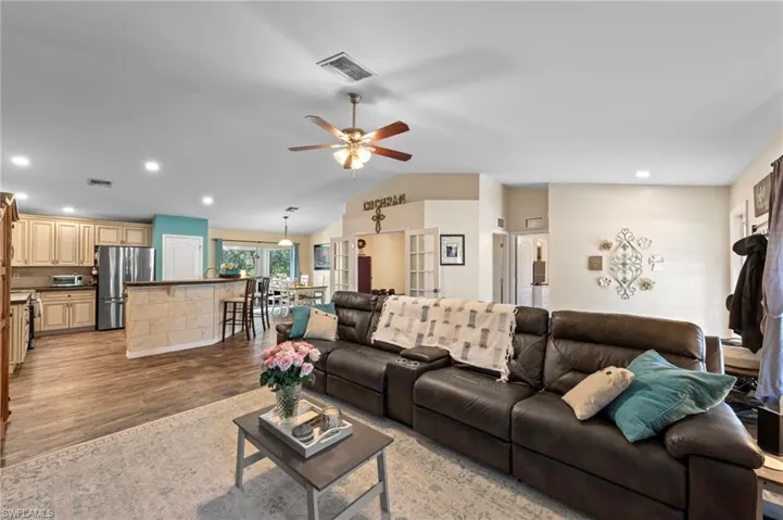 Living room featuring luxury vinyl plank flooring installed in 2021. Overlooking the den, kitchen and dining room.