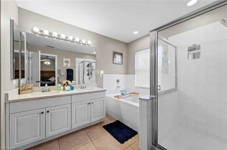 Master bathroom featuring an oversized vanity with quartz countertop (installed in 2026), dual undermount sinks, a soaking tub and walk in shower