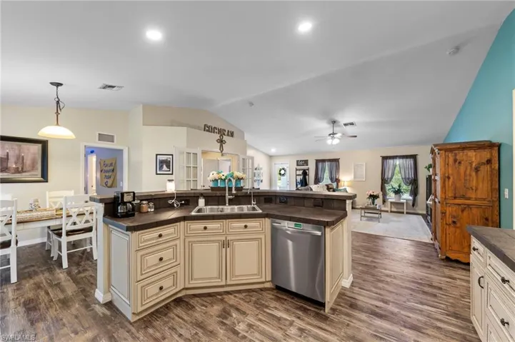 Gorgeous kitchen featuring upgraded cabinets, tumblestone backsplash, cabinet lighting, a tiled island with barstool seating and Samsung stainless steel appliances purchased in 2022