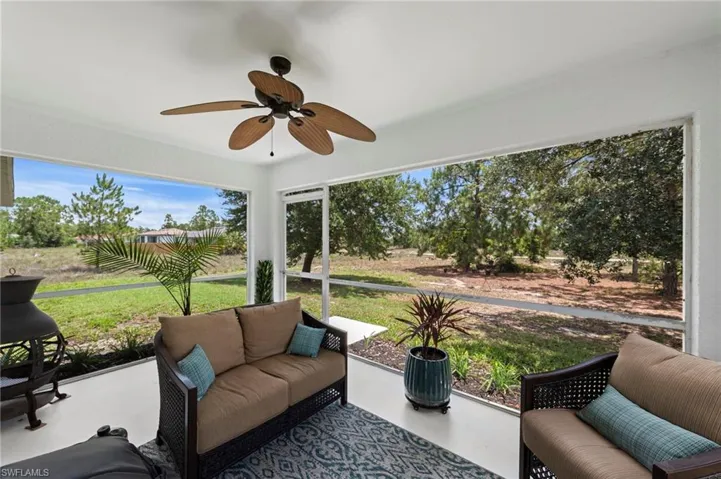 Rear screened lanai with fresh paint and upgraded outdoor fan overlooking a generous yard with over 1/2 acre of space to enjoy!