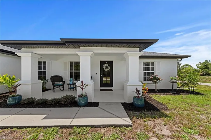 Southern style front porch with fresh paint, mulch and tasteful plants.