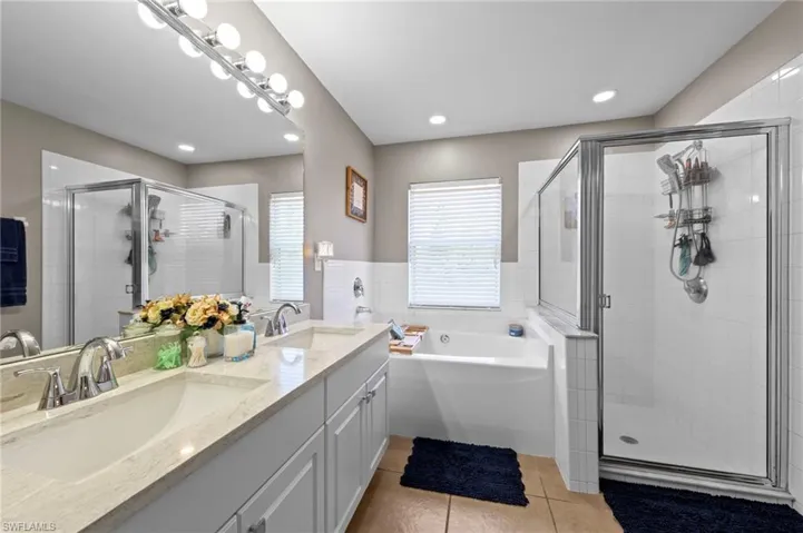 Master bathroom featuring an oversized vanity with quartz countertop (installed in 2026), dual undermount sinks, a soaking tub and walk in shower