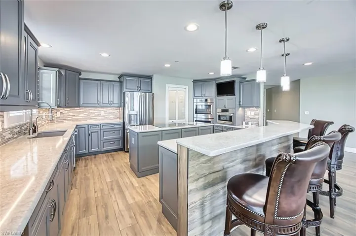 Kitchen featuring tasteful backsplash, a center island, pendant lighting, light tile floors, and recessed lighting