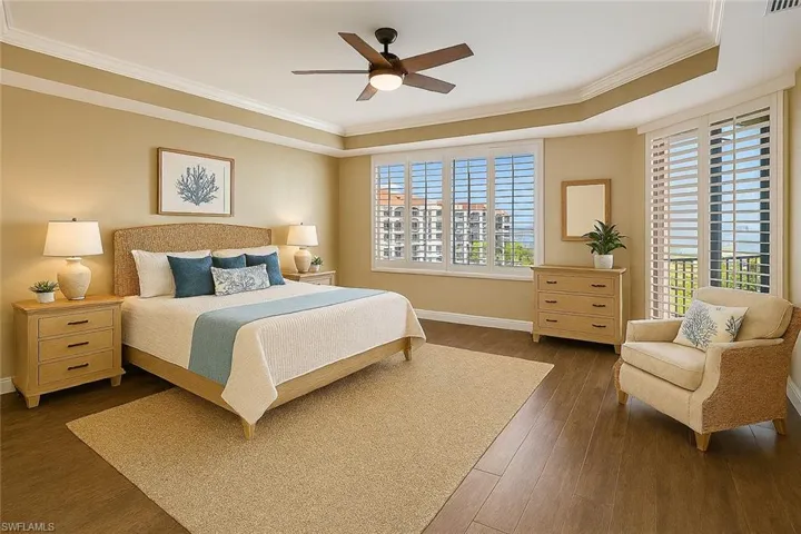 Virtual staged Primary Bedroom featuring crown molding, a raised ceiling,