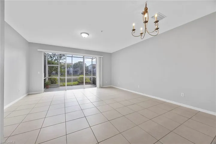 Unfurnished room featuring a chandelier and light tile patterned flooring