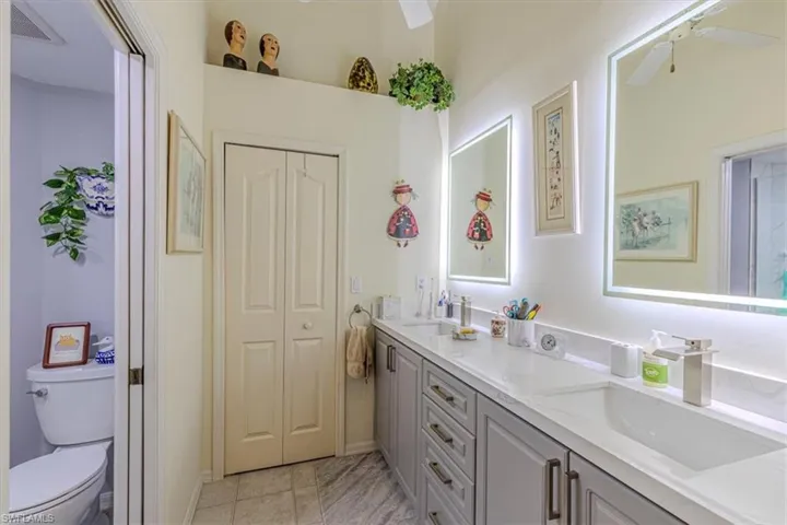Full bathroom with double vanity, a closet, and a ceiling fan