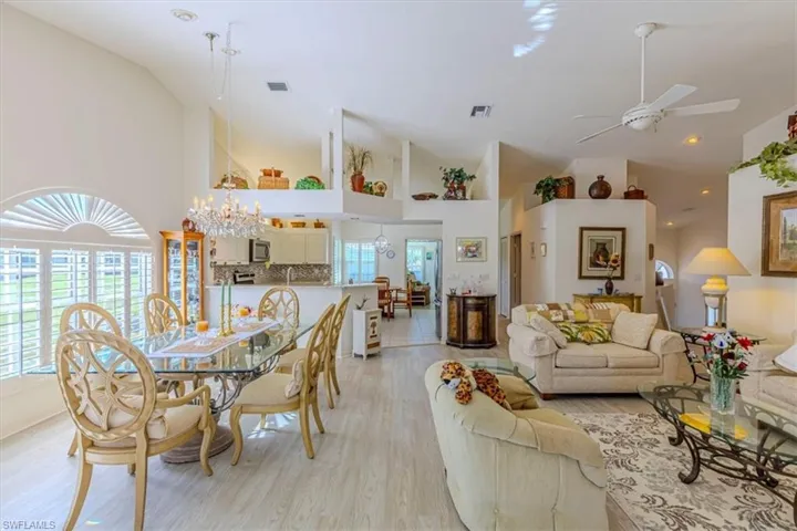 Living area featuring a ceiling fan, high vaulted ceiling, and light wood-style floors