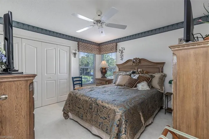 Bedroom featuring light colored carpet, a closet, a ceiling fan, and a textured ceiling