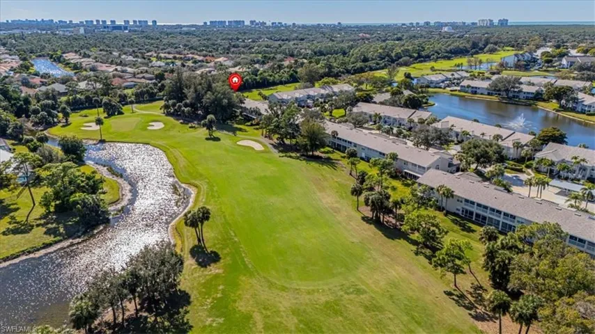Aerial view of property and surrounding area with a local golf course and nearby suburban area