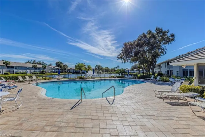 Community pool with a patio area and a residential view