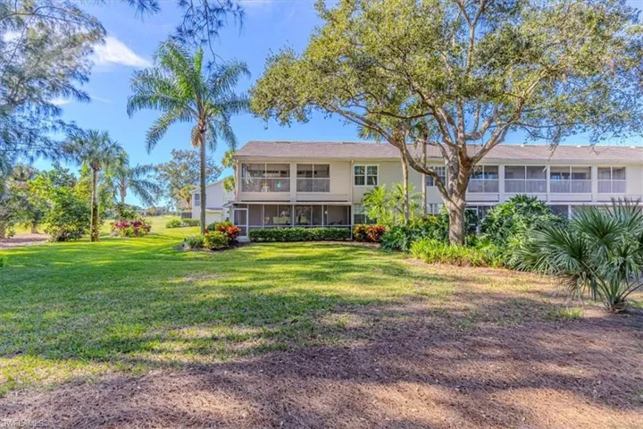 Rear view of property featuring a lawn and a balcony