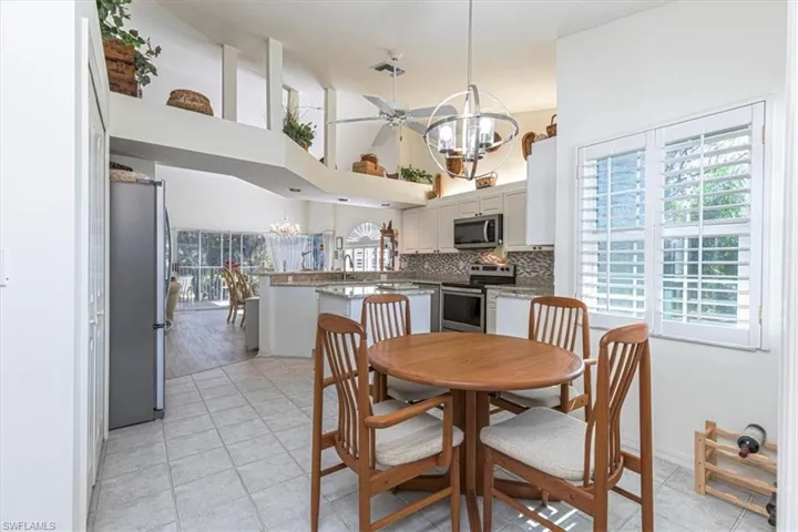 Dining space featuring a chandelier, a high ceiling, and plenty of natural light