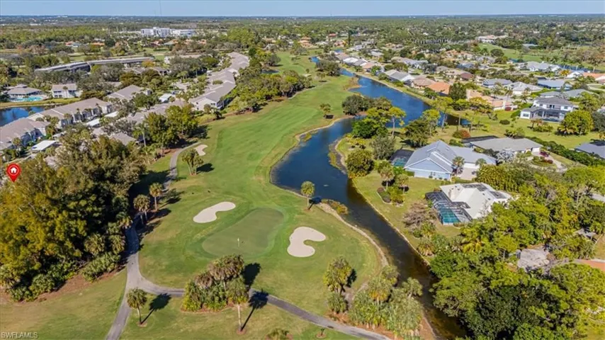 Aerial perspective of suburban area with a local golf course and a large body of water