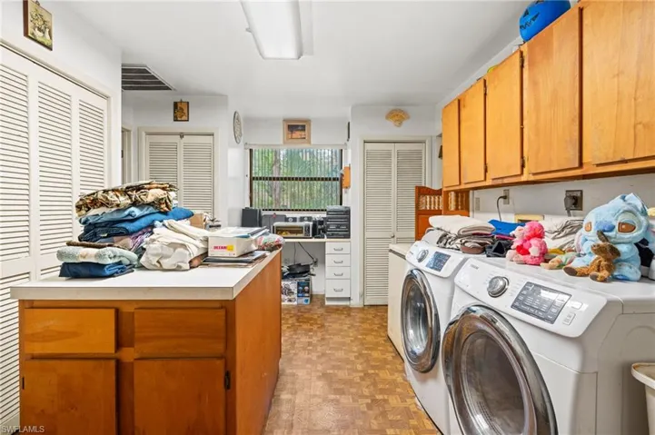Washroom with cabinets, independent washer and dryer, and light parquet flooring