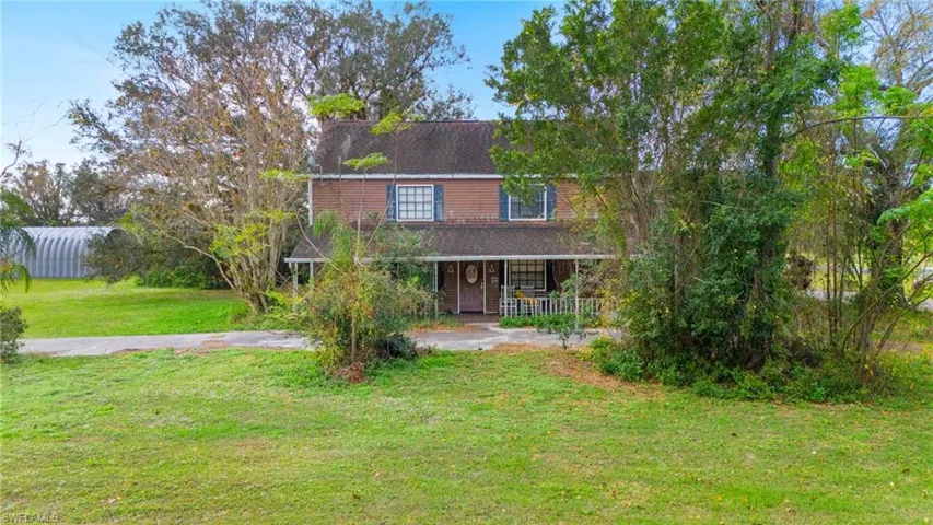 View of front facade featuring a front yard and covered porch