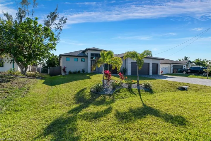 Ranch-style house with a front yard and a garage