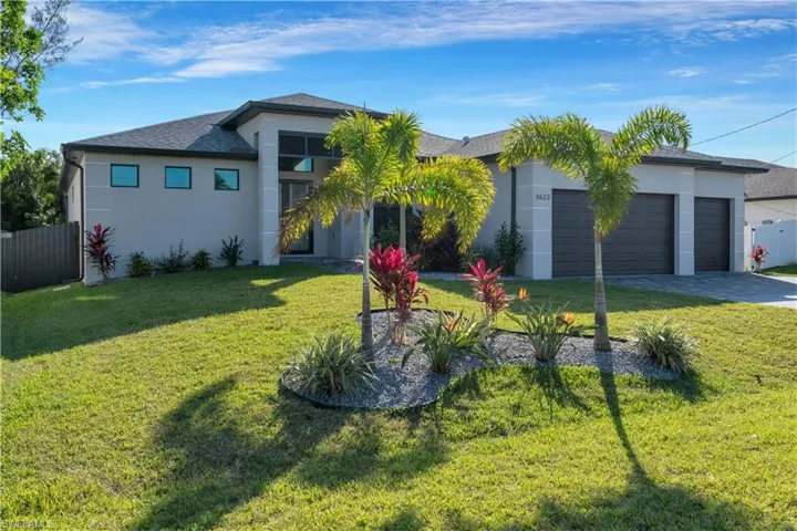 View of front of property featuring a front lawn and a garage