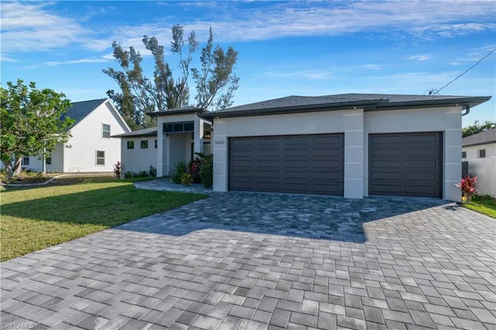 View of front of home featuring a front yard and a garage