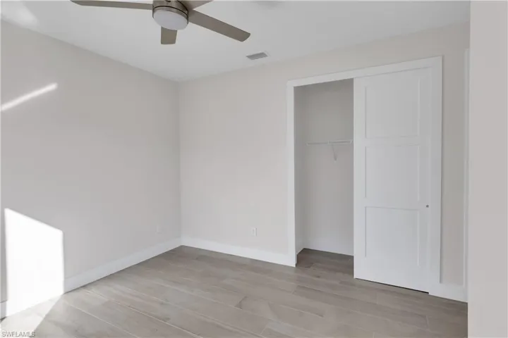 Unfurnished bedroom featuring a closet, ceiling fan, and light hardwood / wood-style floors