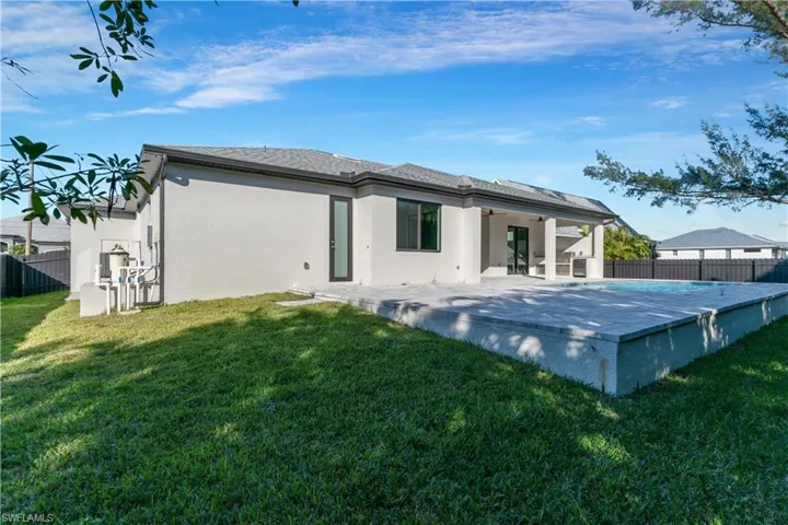 Back of property with a patio, ceiling fan, and a lawn