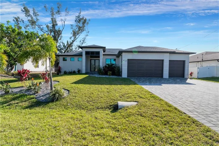 View of front of property with a front yard and a garage