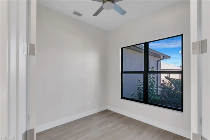 Empty room with ceiling fan and light wood-type flooring