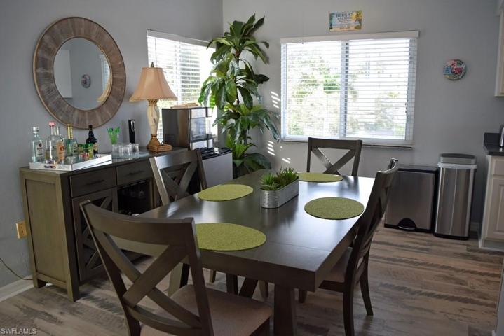 DINING AREA WITH 2 WINDOWS.  PORCELAIN TILE PLANK FLOORING.  KITCHEN IS TO RIGHT.