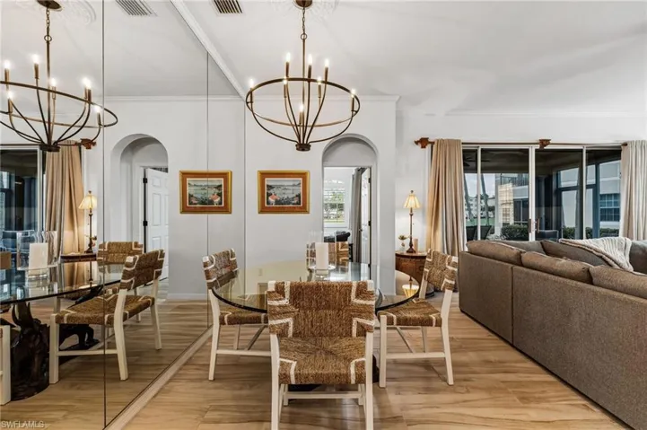 The dining area, ideally located just off the kitchen for effortless entertaining, features a stunning chandelier and dramatic floor-to-ceiling mirrors that beautifully enhance the sense of space.