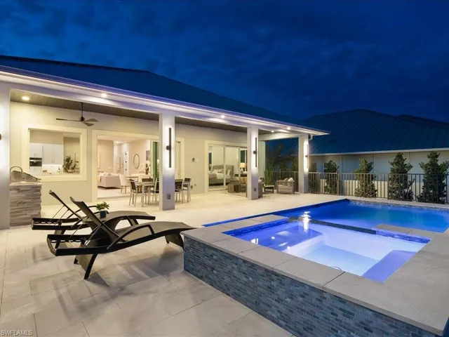 Dusk view of pool, spa, and outdoor living area