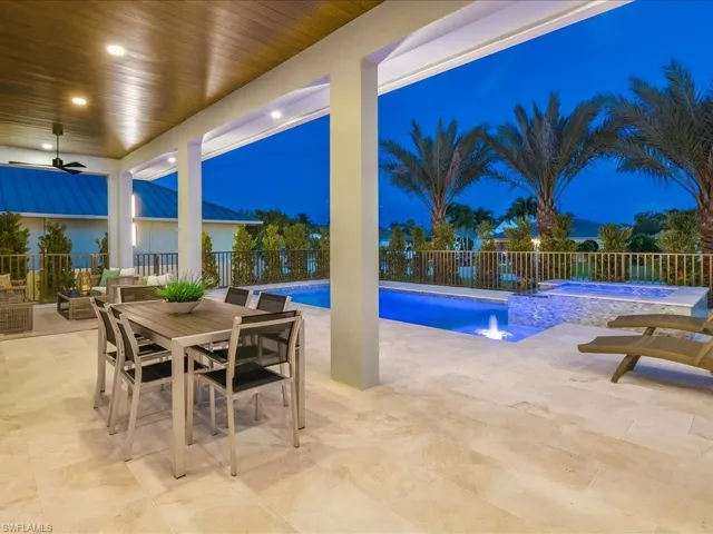 Twilight pool view with illuminated outdoor entertaining spaces