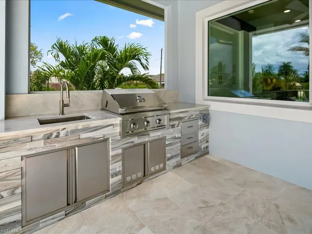 Outdoor kitchen with built-in grill, sink, and prep space