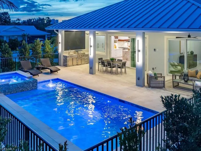 Twilight pool view with illuminated outdoor entertaining spaces